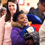 Kids accept coats from ActioNeters